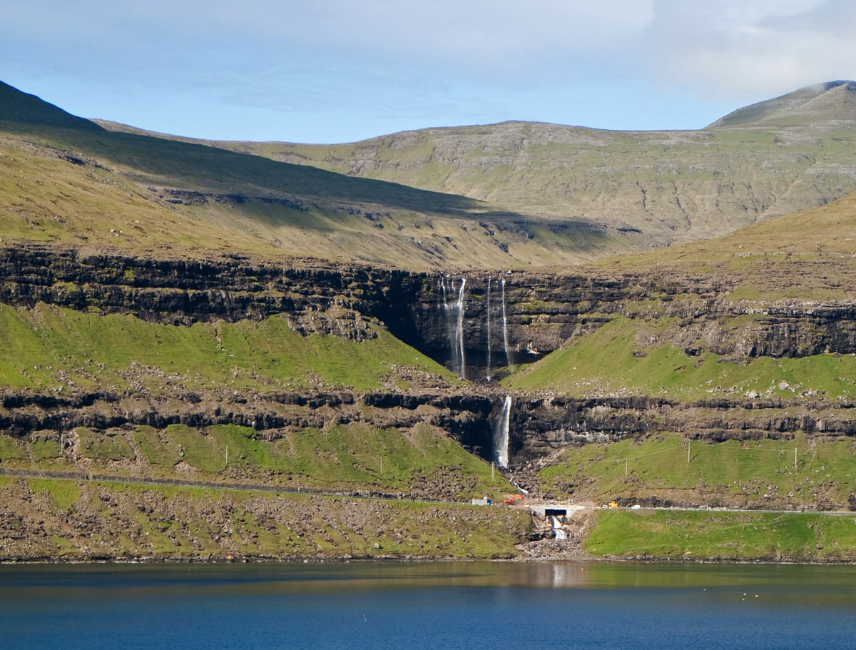 Fossá falls in Faroe Islands. Note vehicles on the road