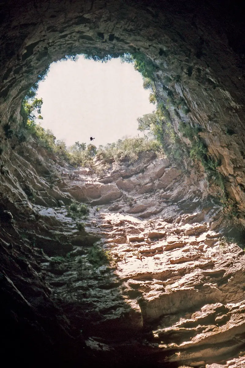 Caver rappelling down into the Sótano de las Golondrinas, Mexico