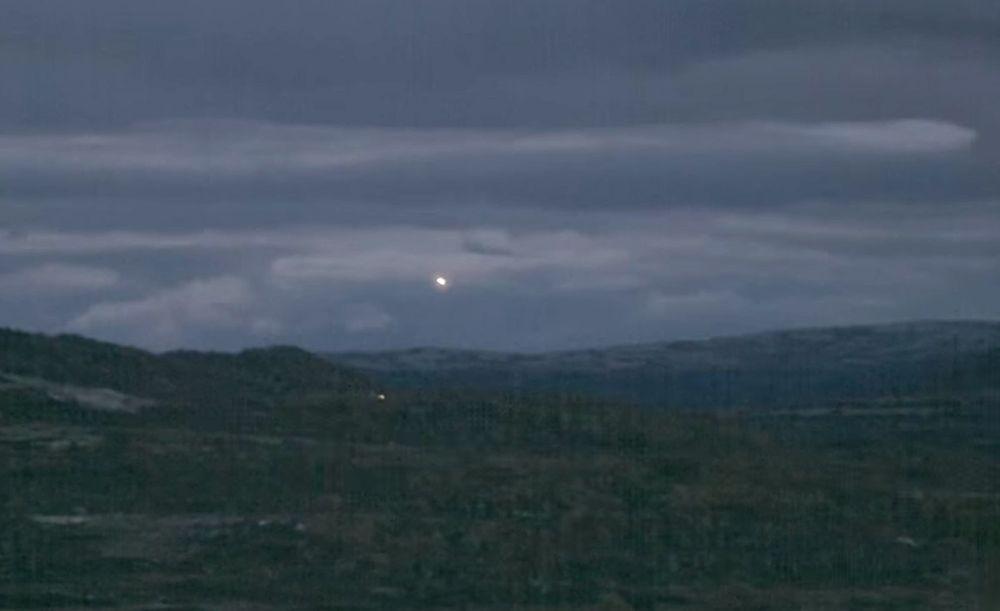 Hessdalen lights in February 2015. Two moving lights are seen - one in the sky (this is not Moon) and one over the forest.