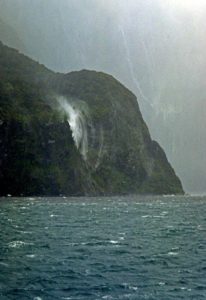 Milford Sound. Waterfall thrown back by a strong gale. Note the much higher falls in the background